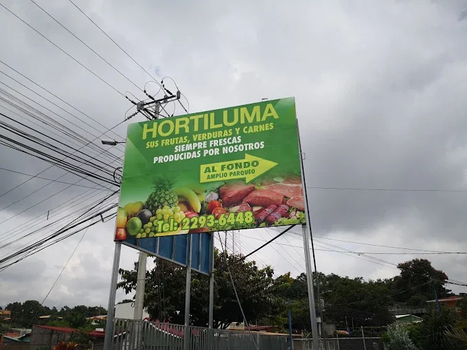 Rótulo de Hortiluma sobre la carretera, con indicación de parqueo amplio