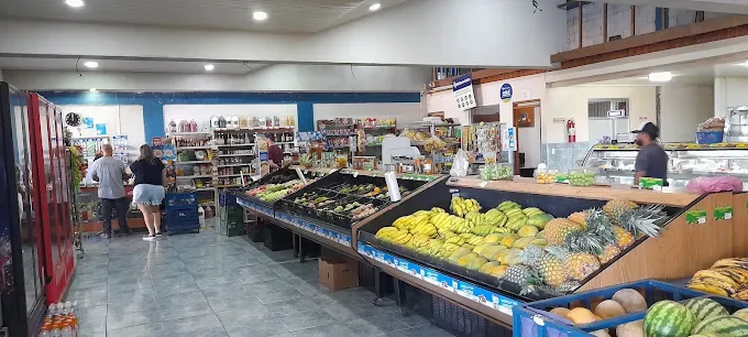 Interior del punto de venta de Hortiluma en San Antonio de Belén, con clientes y producto fresco